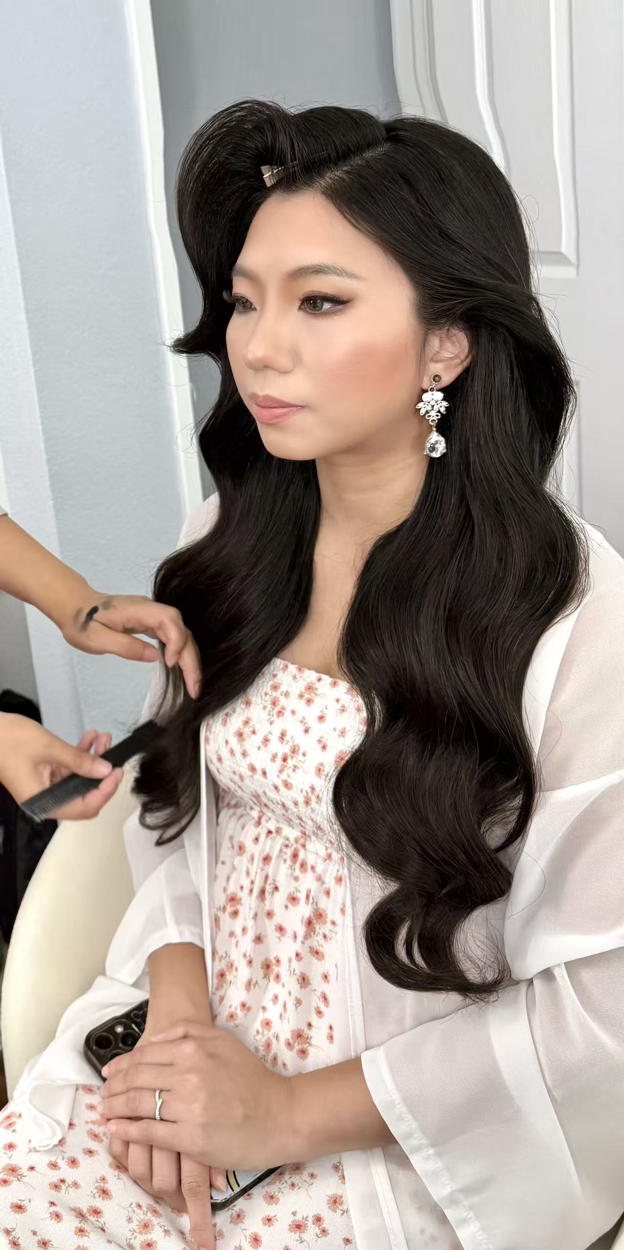 Bride with long Hollywood waves during final hair styling